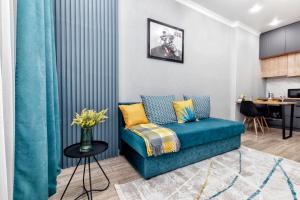 a living room with a blue couch and a table at "Бирюзовый оазис" Премиум квартира на Туран - Улы Дала рядом с Легкоатлетическим комплексом in Astana