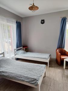 a bedroom with two twin beds and a chair at Comfort Mile Apartments in Vilnius