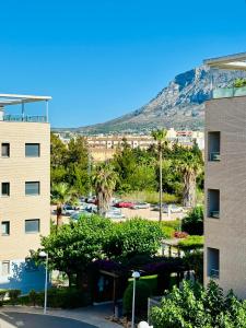 una vista de un edificio con una montaña en el fondo en Jardines de Denia 24, en Denia