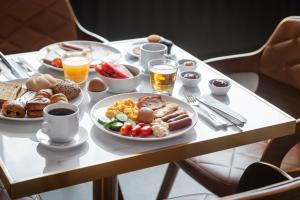 a breakfast table with plates of breakfast foods and drinks at Rise Urban Art Hotel in Larnaca
