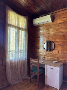 a wooden room with a desk and a window at Kutaisi airport guesthouse in P'arts'khanaqanevi +2 photos