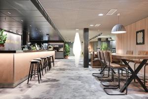 a restaurant with a bar with chairs and a table at Comfort Hotel Xpress Helsinki Airport Terminal in Vantaa