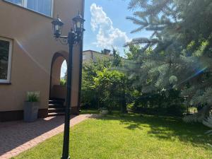 a street light next to a house with a tree at Apartamenty Uchnasta in Busko-Zdrój
