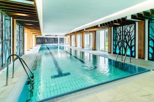 ein Hallenbad mit blauem Wasser in einem Gebäude in der Unterkunft Medica Hotel Krojanty Bory Tucholskie in Chojnice