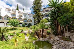 a hotel with a pond in front of a building at Lovely apartment in peaceful area in Mijas