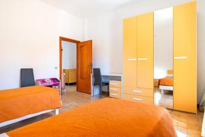 una camera con 2 letti, una scrivania e uno specchio di Villa Bianca a Pulsano