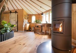 a large kitchen with a fireplace in a room with wooden floors at Baumhaus Solitär in Borstel