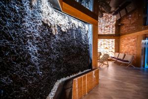 eine Wand mit einem großen Bildschirm in einem Raum mit Stühlen in der Unterkunft Medica Hotel Krojanty Bory Tucholskie in Chojnice