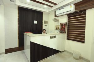 a woman sitting at a counter in a room at Hotel KANDA CONTINENTAL 50 Mtr from golden temple in Amritsar