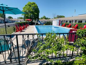a swimming pool with chairs and an umbrella at Holiday Home 7865LL in Niagara Falls
