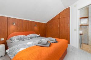 a bedroom with an orange bed and wooden cabinets at Villa ZaVaLa Brzac in Brzac +38 photos