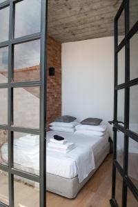two beds in a room with a window at PositiveSpace Kalamata Heights in Kalamata