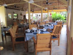 comedor con mesas y sillas de madera en Flower Paradise Bungalows & Swiss Restaurant Roestiland, en Lamai