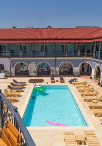 a swimming pool with chairs and a building at HOTEL KM 0 in Costinesti