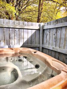 a bath tub in front of a wooden fence at Snowdrop 10-Hot Tub-Woodlandlodges-St Clears-Pembrokeshire in Carmarthen +5 photos