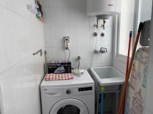 Un pequeño baño con lavadora y lavabo. en Central Puerto, en Puerto de Mazarrón