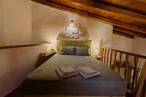 a bedroom with a bed with two towels on it at Tonia's Cottage in Arkalochori