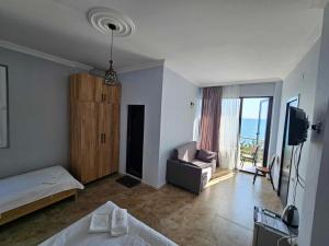 una camera da letto con un letto, un divano e una televisione di IVERIA BEACH a Kobuleti