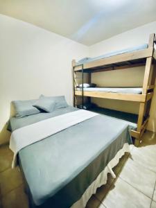 a bedroom with two bunk beds in a room at Casa e Kitnet - Praia Grande Centro in Arraial do Cabo
