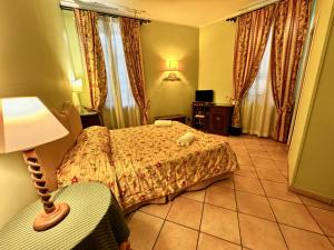 a hotel room with a bed and a lamp at Villa Le Camelie Siena in Siena