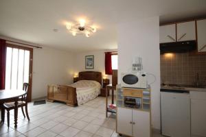 a kitchen and a bedroom with a bed and a table at Chez Marie-Anne in Sacquenay