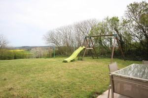 a playground with a yellow slide in a field at Chez Marie-Anne in Sacquenay