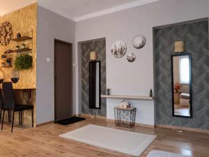 a living room with a chair and a mirror at Apartman ClaRa in Štúrovo