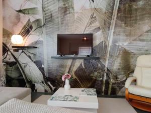 a living room with a tv on a wall at Apartman ClaRa in Štúrovo