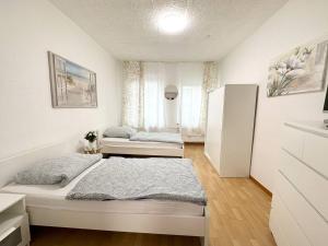 ein weißes Schlafzimmer mit zwei Betten und einem Kühlschrank in der Unterkunft Work and Stay Apartment in Troisdorf in Troisdorf