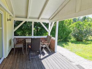 a porch with a table and chairs on it at Haus Kranichweide in Bodstedt