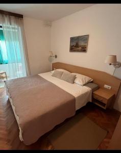 Un dormitorio con una cama grande y una ventana. en Apartments Medulin, en Medulin