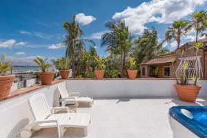 a patio with white chairs and a swimming pool at Villa Thalissa by Perle di Puglia in Taranto