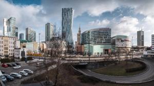 a city with cars on a road and buildings at Złota City Centre, Sun & Snow in Warsaw