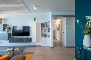 Televízia a/alebo spoločenská miestnosť v ubytovaní "I MORI LUXORY APARTMENTS" - Attico mansardato con incantevole vista mare