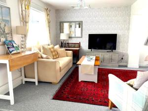a living room with a couch and a tv at Glenburn, Peaceful Accommodation Fochabers in Fochabers