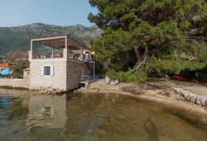 a house on the shore of a body of water at Stone sea apartment in Risan
