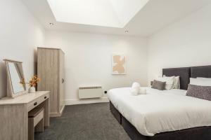 a bedroom with two beds and a dresser and a mirror at Wellington Lodge in Ayr