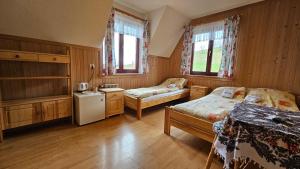 a small bedroom with two beds and a refrigerator at PG Szymonek in Male Ciche