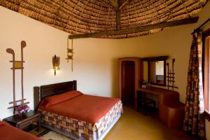 a bedroom with a bed and a desk in a room at Samburu Sopa Lodge in Archers Post