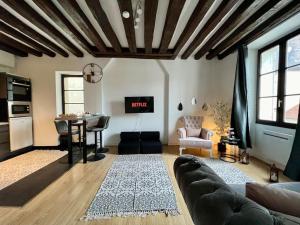 ein Wohnzimmer mit Couch und Tisch in der Unterkunft Nid de Montereau - Centre - 4 personnes in Montereau-faut-Yonne