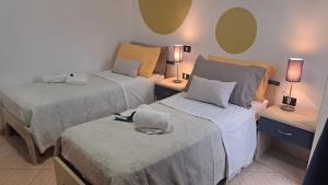 a room with two beds and two tables with lamps at MariMare B&B in Pozzallo