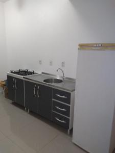 a kitchen with a sink and a refrigerator at Sobrado 500mts Shooping in Joinville