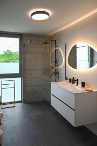 a bathroom with a white sink and a shower at Sea House in Tkon