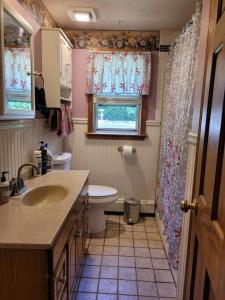 een badkamer met een wastafel en een toilet en een raam bij Lake Congamond Suffield House in Granby +32 foto's