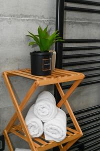a bamboo shelf with towels and a potted plant on it at Sea House in Tkon