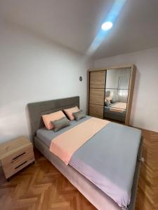 a bedroom with a large bed and a mirror at Apartment Vrbisao in Cetinje