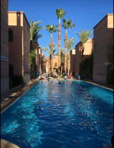 マラケシュにあるRiad Al Nakhilのリゾート内のヤシの木があるスイミングプール