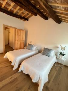 two beds in a room with wooden floors at Follinetta10 - enjoy holiday home in the Prosecco hills in Follina +30 photos