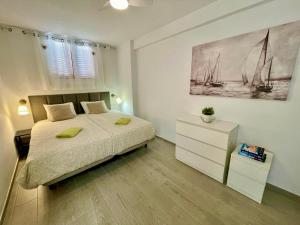 a bedroom with a bed and a dresser and a painting at Sunset Copacabana in Playa Fañabe