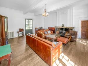 Una sala de estar con muebles de cuero y chimenea. en Retraite Royale à Valentine, en Valentine